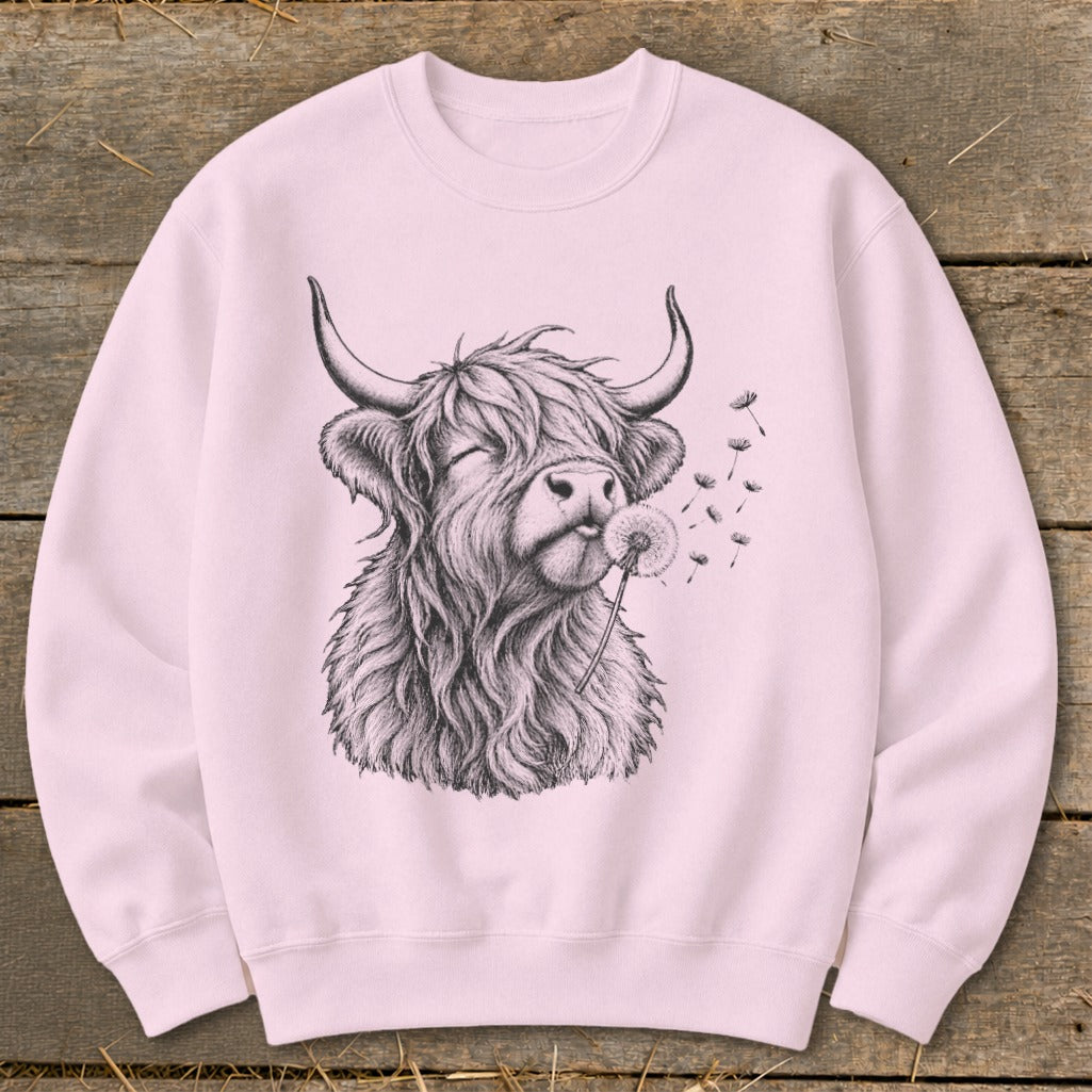 Pink sweatshirt with a black sketch of a Highland cow blowing dandelion seeds.