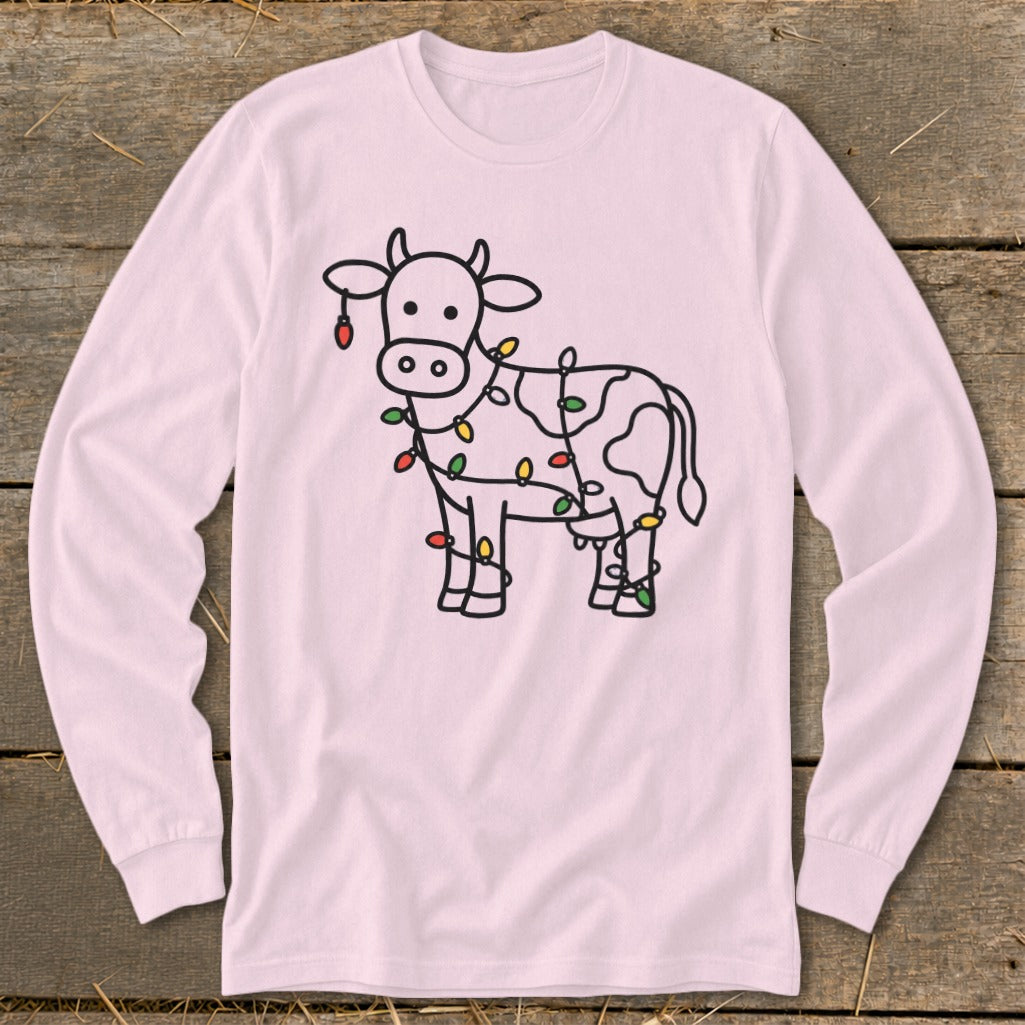 Pink long-sleeve shirt with a black outline drawing of a cow decorated with colorful Christmas lights.