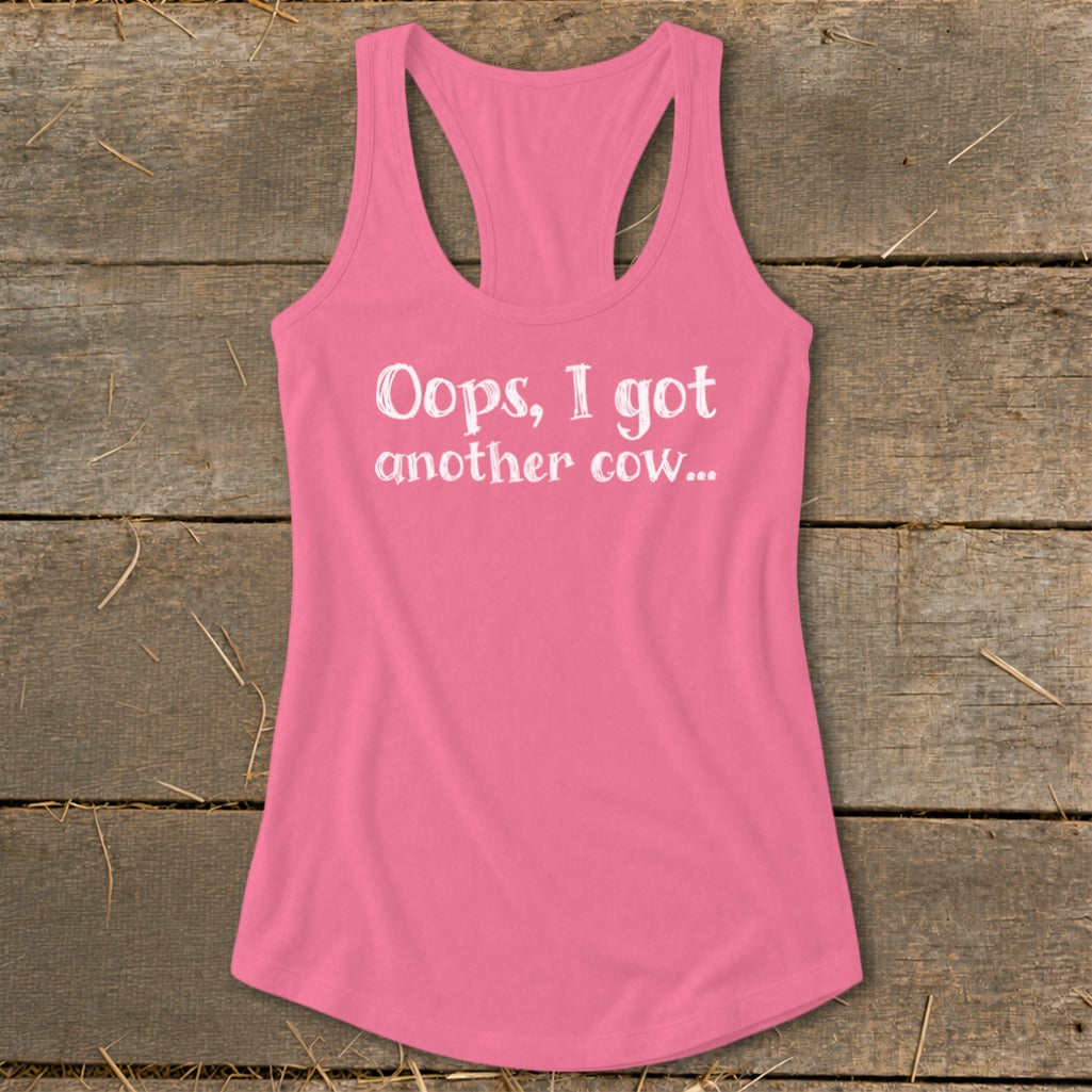 Pink racerback tank top with white text that reads "Oops, I got another cow..."