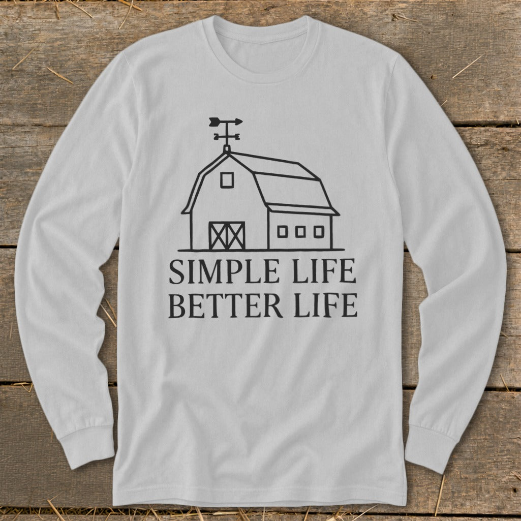 White long-sleeve shirt with a line drawing of a barn and text reading "Simple Life Better Life."
