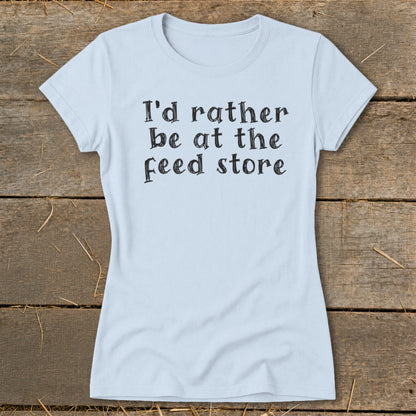 Light blue t-shirt with black text that reads "I'd rather be at the feed store".