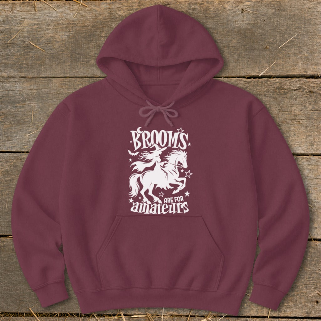 Maroon hoodie with white graphic: witch riding horse, text "BROOMS ARE FOR AMATEURS".