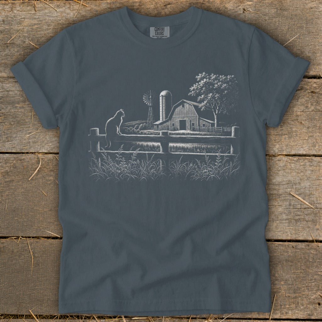 T-shirt with white line art of a farm scene: cat, barn, windmill, fence, and tree.