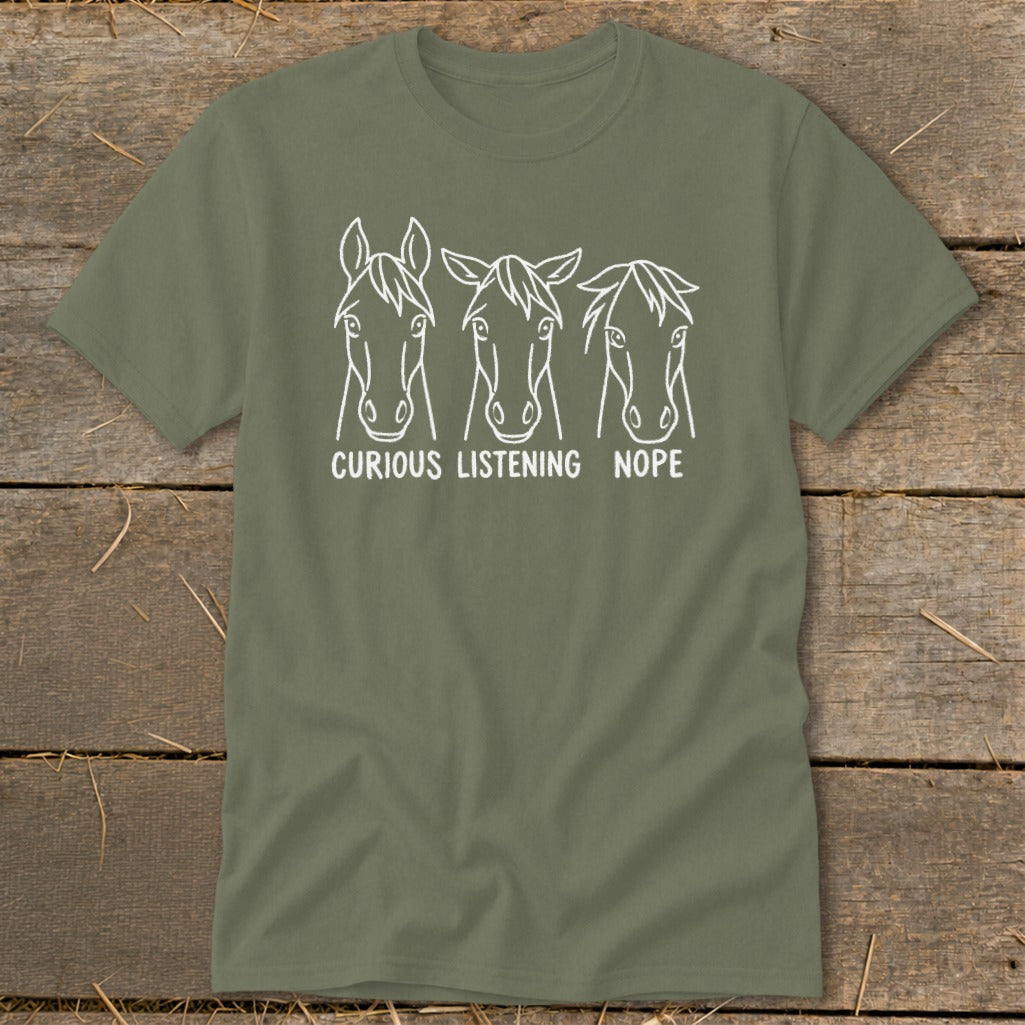 Olive green t-shirt featuring a white graphic of three horse heads labeled Curious, Listening, and Nope.
