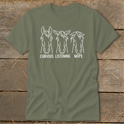 Olive green t-shirt featuring a white graphic of three horse heads labeled Curious, Listening, and Nope.