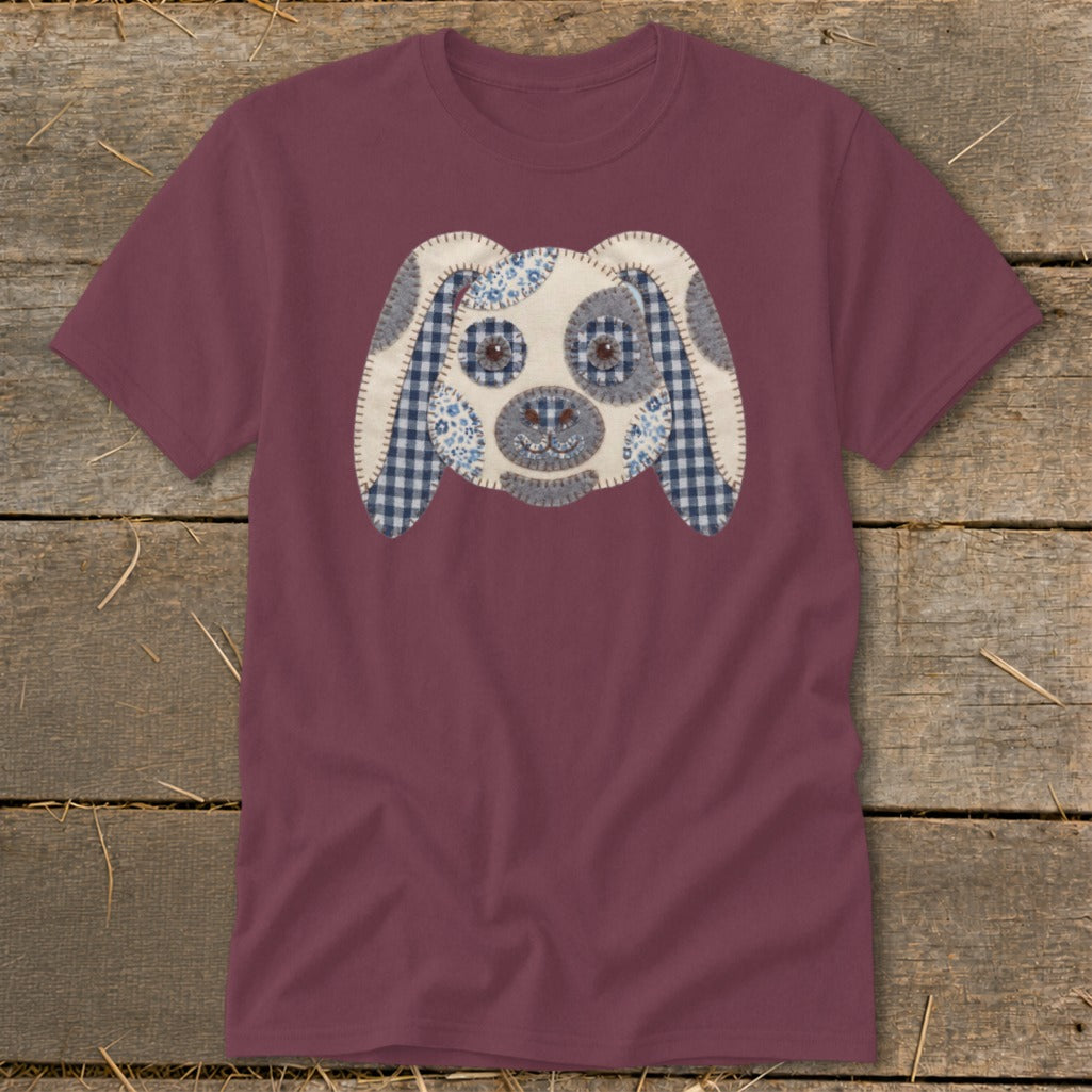 Maroon t-shirt with a fabric applique dog face featuring blue gingham and floral patterns.