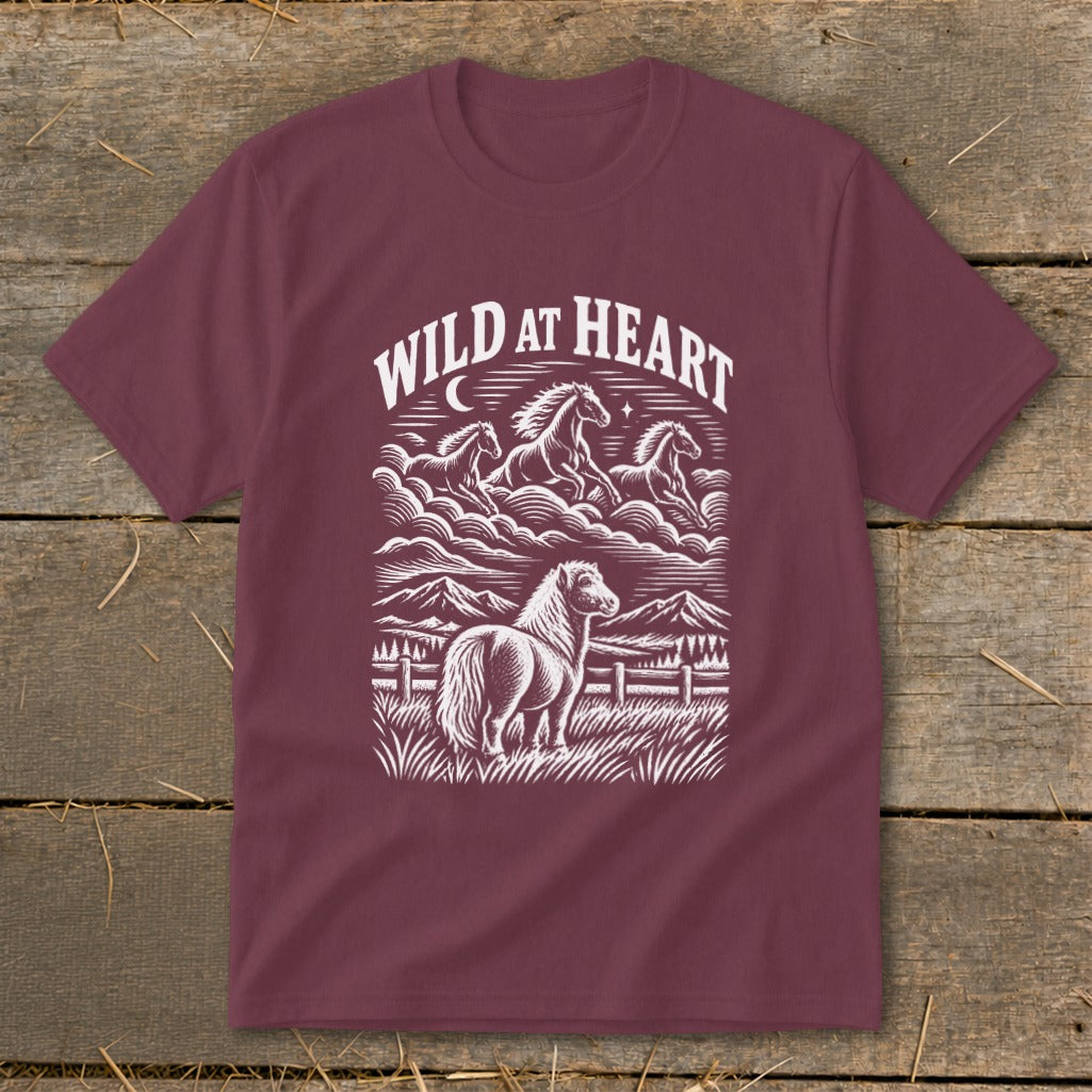 Maroon t-shirt with "Wild At Heart" text and a horse illustration with mountains and running horses.