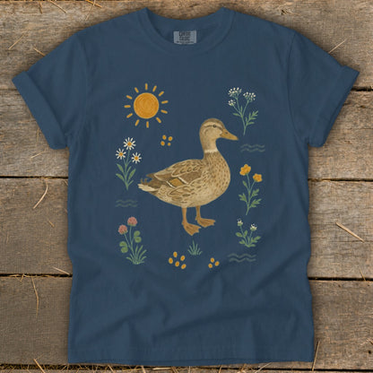 Navy t-shirt with a watercolor duck and floral illustration, sun, and wavy lines.