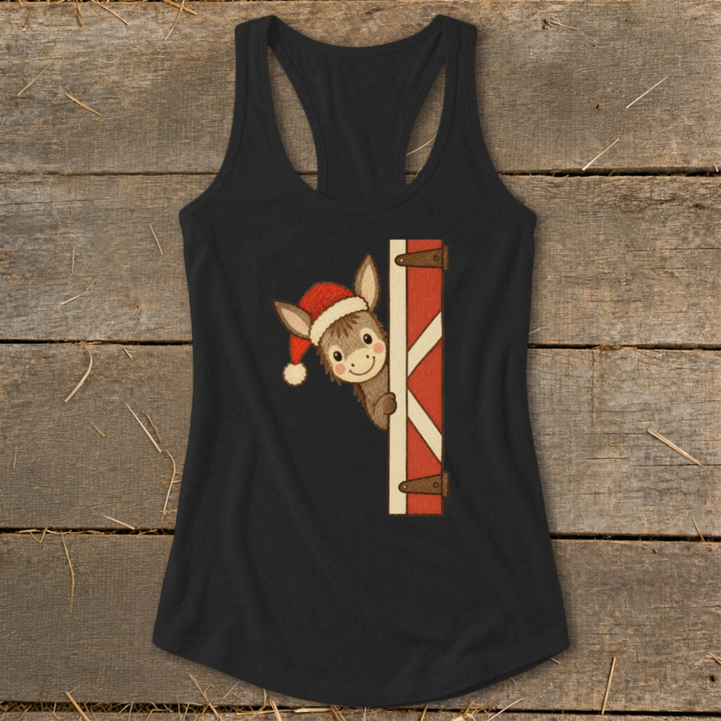 Donkey wearing Santa hat peeking from behind barn door.