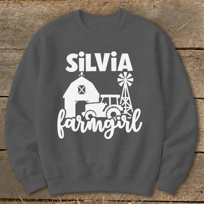 White text "SILVIA farmgirl" with farm graphic on charcoal sweatshirt.