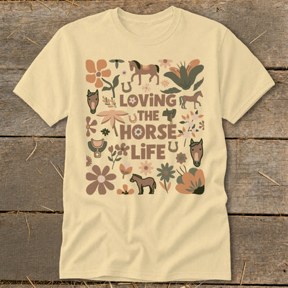 Cream t-shirt with a graphic design of horses, flowers, and text "Loving the Horse Life".
