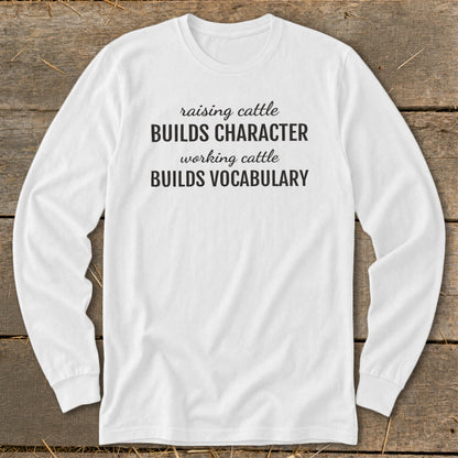 White long sleeve shirt with text "Raising cattle builds character, working cattle builds vocabulary."