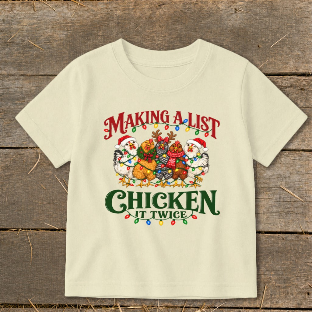 Cream t-shirt with chickens in holiday attire, "Making a list chicken it twice" text.