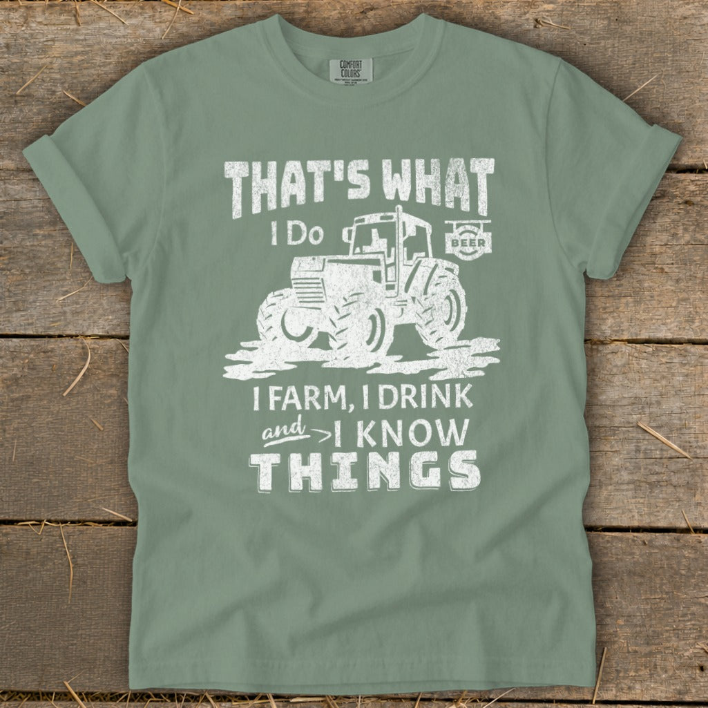 Green t-shirt with white distressed graphic of a tractor and text that reads "THAT'S WHAT I DO, I FARM, I DRINK AND I KNOW THINGS".