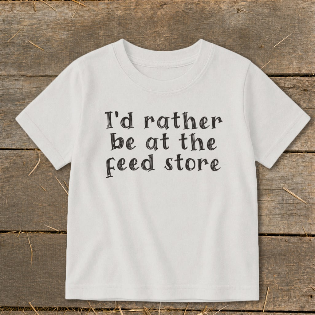 White t-shirt with black text that reads "I'd rather be at the feed store."