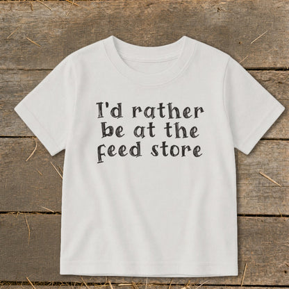 White t-shirt with black text that reads "I'd rather be at the feed store."