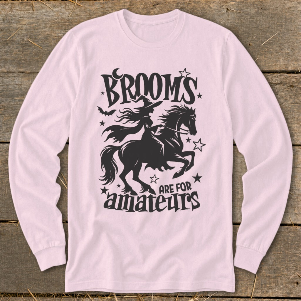 Black graphic on pink shirt reads "Brooms are for amateurs" with witch on horse.