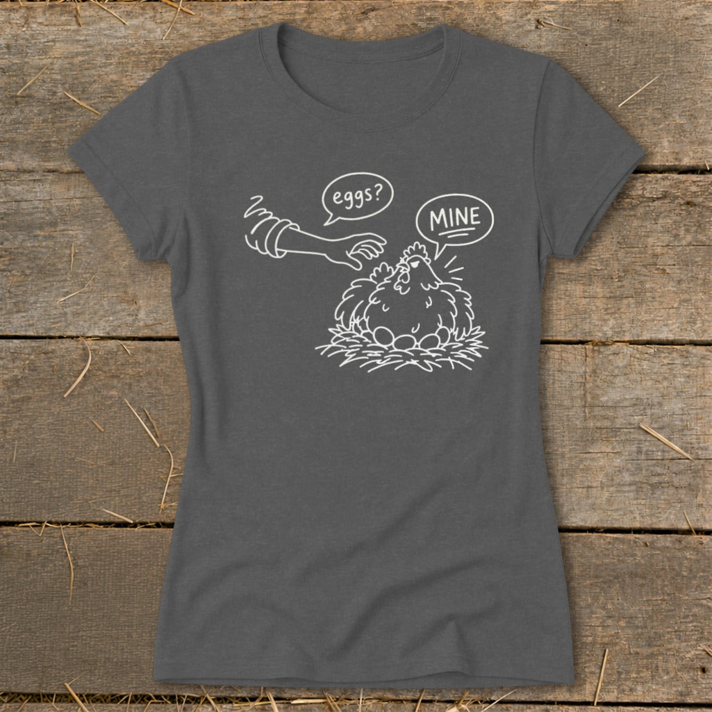 T-shirt with line drawing of hen protecting eggs, "eggs?" speech bubble and "MINE" speech bubble.