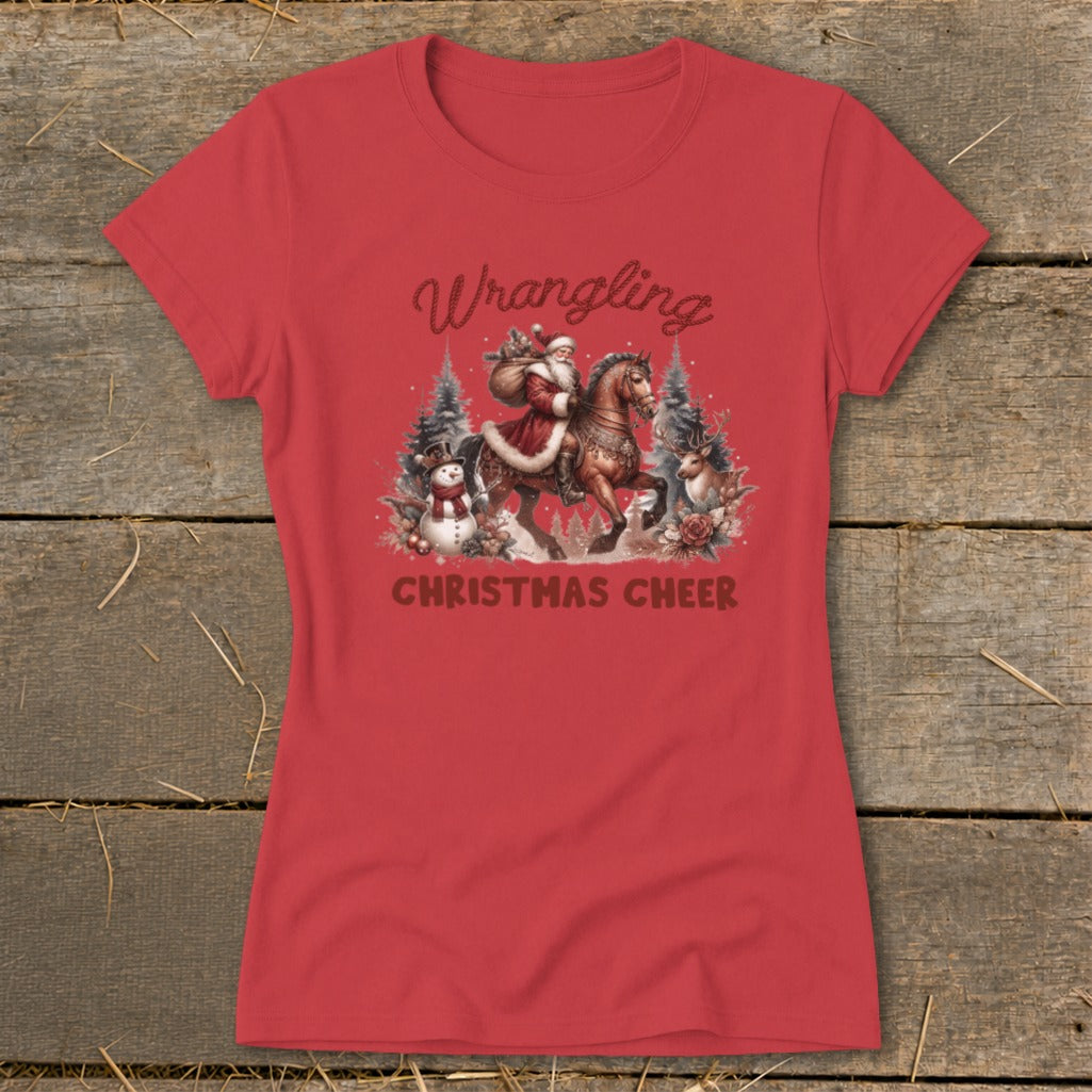 Red t-shirt with Santa on horseback, snowman, deer, and text "Wrangling Christmas Cheer".