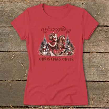 Red t-shirt with Santa on horseback, snowman, deer, and text "Wrangling Christmas Cheer".