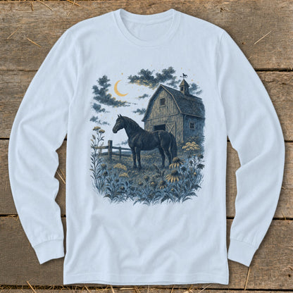 Black horse standing in a field of flowers by a barn under a crescent moon.