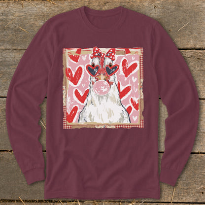 Chicken with heart sunglasses and bow blowing bubblegum on pink hearts background.