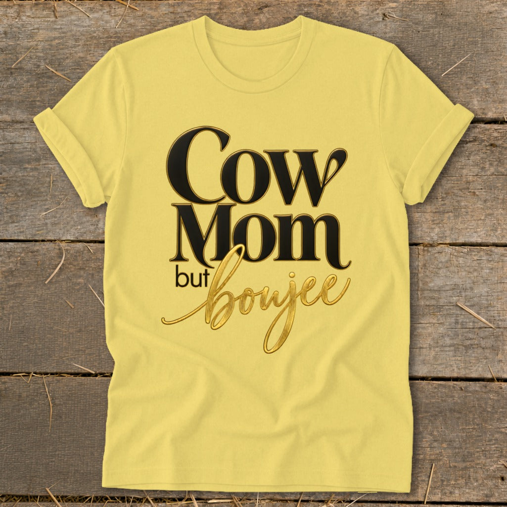 Yellow t-shirt with text "Cow Mom but boujee" in black and gold script.