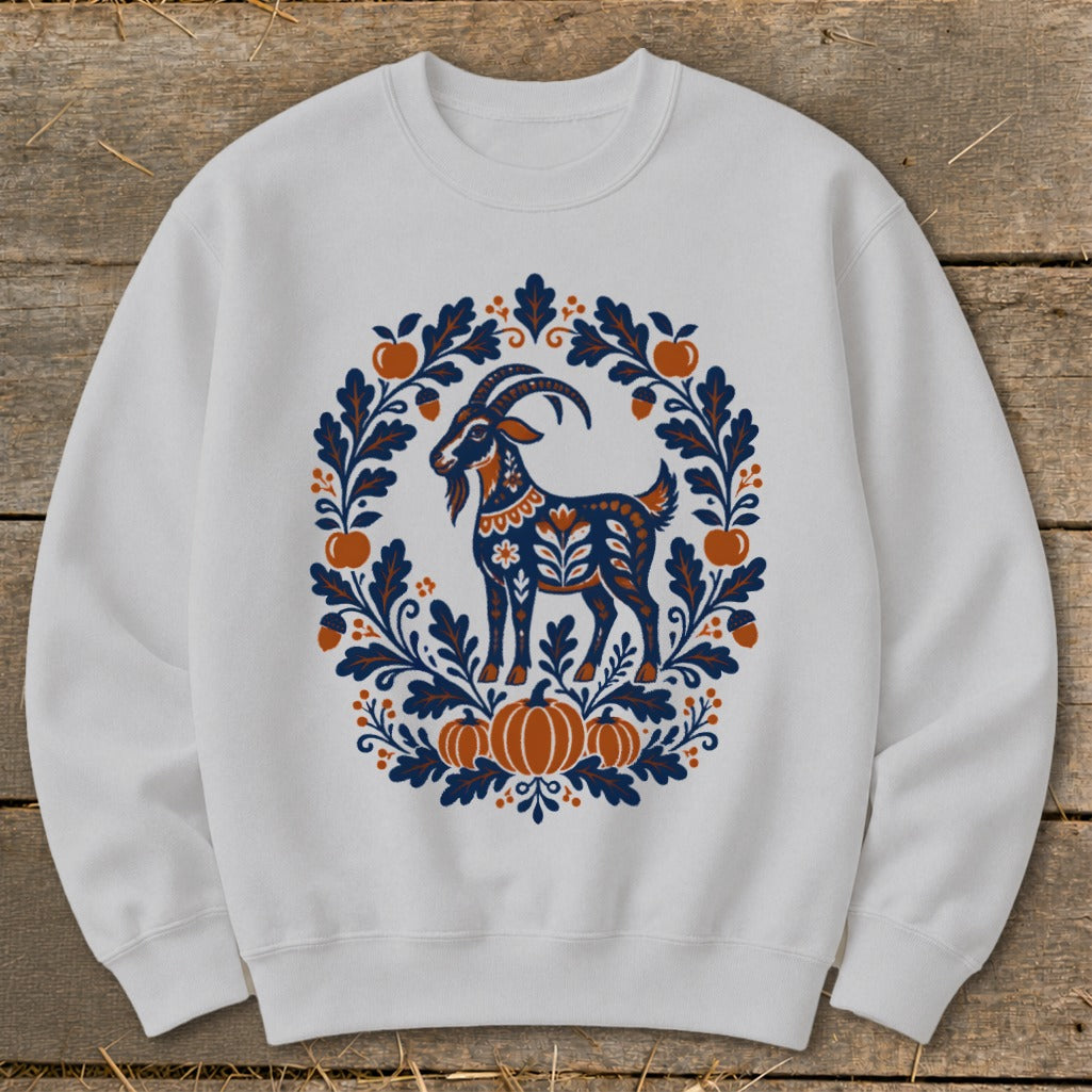 Light gray crewneck sweatshirt featuring a folk art graphic of a goat surrounded by autumn leaves, pumpkins, and apples.
