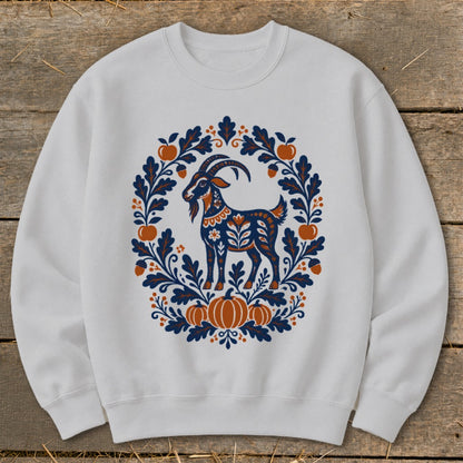 Light gray crewneck sweatshirt featuring a folk art graphic of a goat surrounded by autumn leaves, pumpkins, and apples.