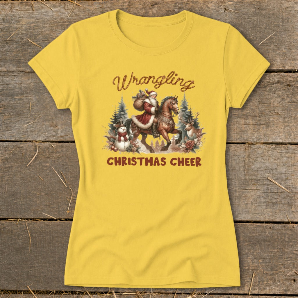 Yellow t-shirt with Santa on a horse, snowman, reindeer, and trees. Text: "Wrangling Christmas Cheer."