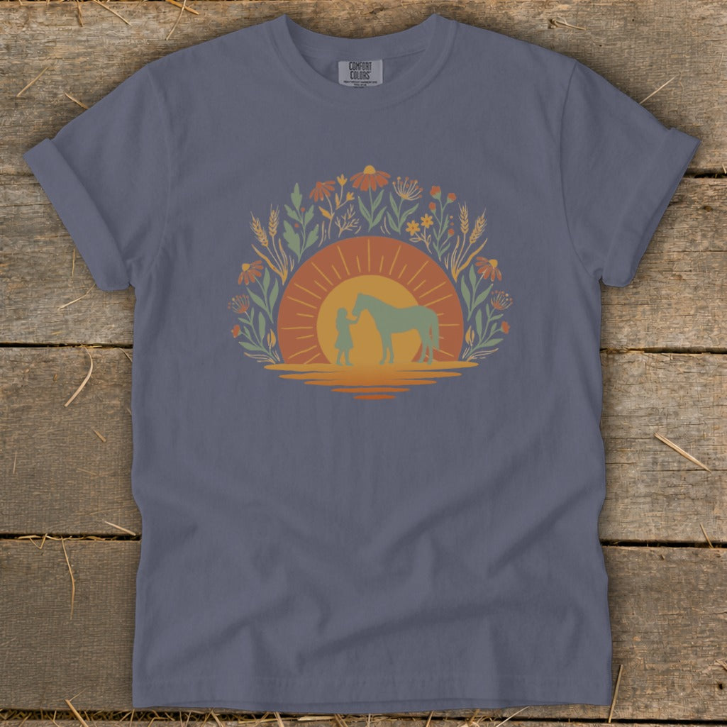 Girl and horse silhouette in sun, surrounded by flowers and wheat.