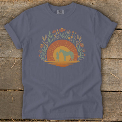 Girl and horse silhouette in sun, surrounded by flowers and wheat.