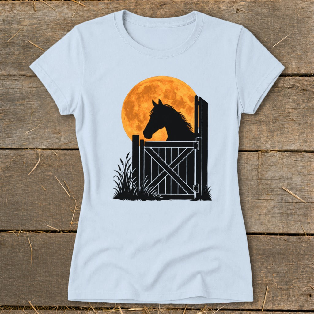 Light blue t-shirt featuring a black silhouette graphic of a horse looking out of a stable door against a large orange moon.
