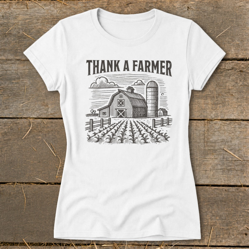 White t-shirt with "Thank A Farmer" text and barn, silo, and crops graphic.