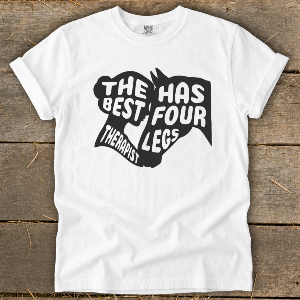 White t-shirt with black graphic text "The Best Therapist Has Four Legs" and horse silhouette.