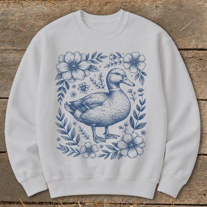 White sweatshirt with blue duck and floral illustration.