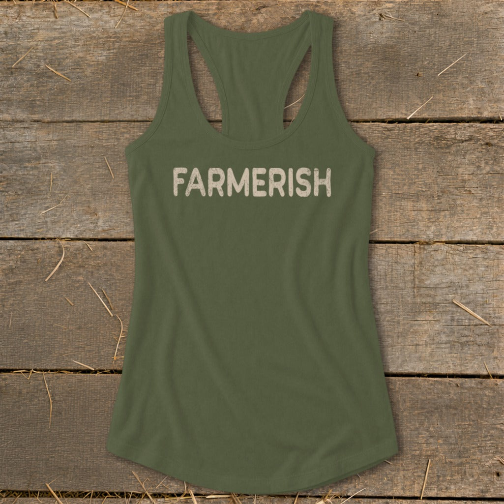 Olive green tank top with "FARMERISH" text, laid on rustic wood with straw.