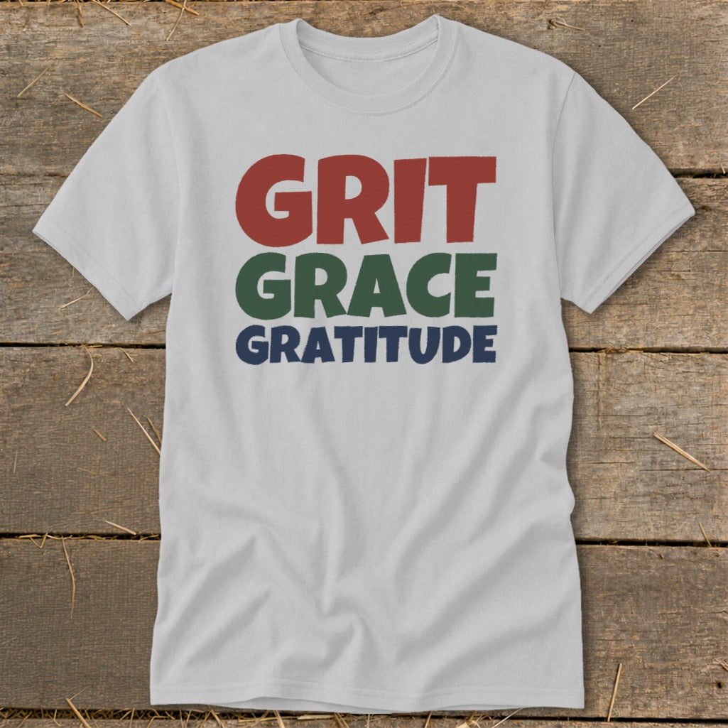 A light gray t-shirt featuring the stacked text Grit, Grace, and Gratitude in red, green, and blue.