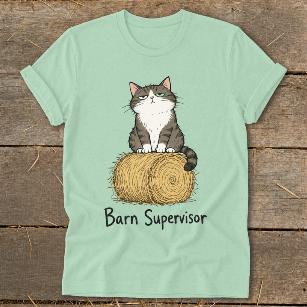 Light green t-shirt with grumpy cat illustration sitting on a hay bale with "Barn Supervisor" text.