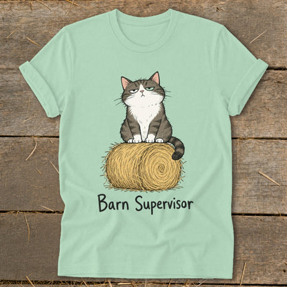 Light green t-shirt with grumpy cat illustration sitting on a hay bale with "Barn Supervisor" text.