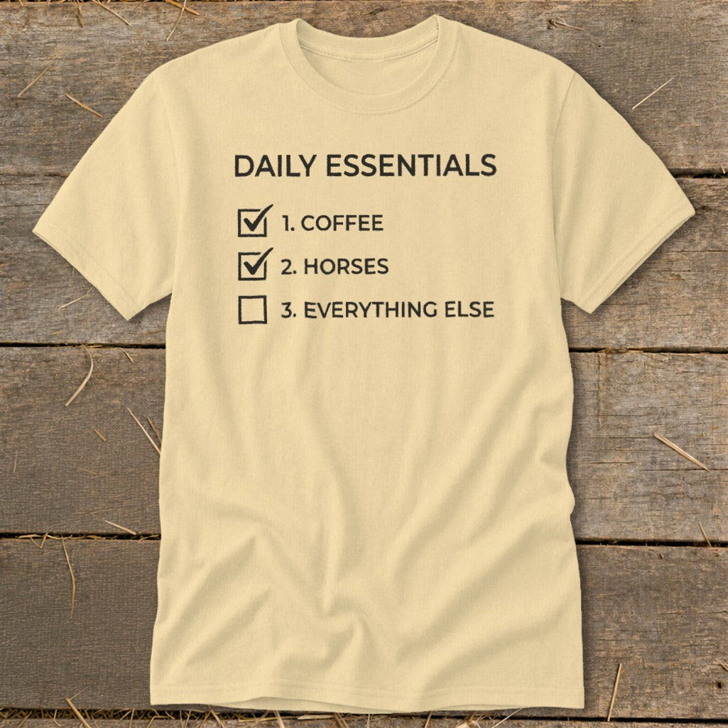 Light yellow t-shirt with "DAILY ESSENTIALS" and a checklist including coffee and horses.