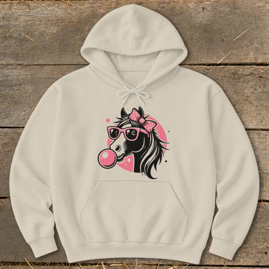 Cream hoodie with a black horse head graphic blowing a pink bubblegum bubble.