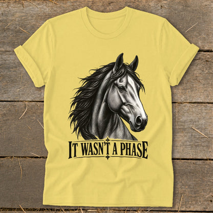 Yellow t-shirt with a black and white horse illustration and the text "IT WASN'T A PHASE".