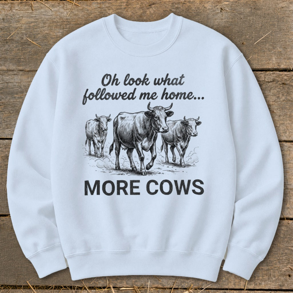 Light blue sweatshirt with a sketch of three cows and text "Oh look what followed me home... MORE COWS".
