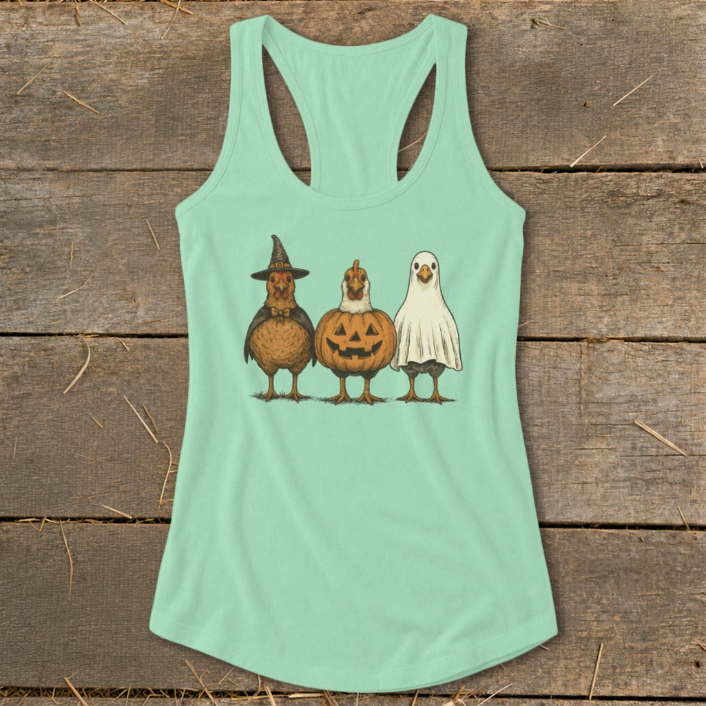Three chickens in Halloween costumes: witch, pumpkin, and ghost.