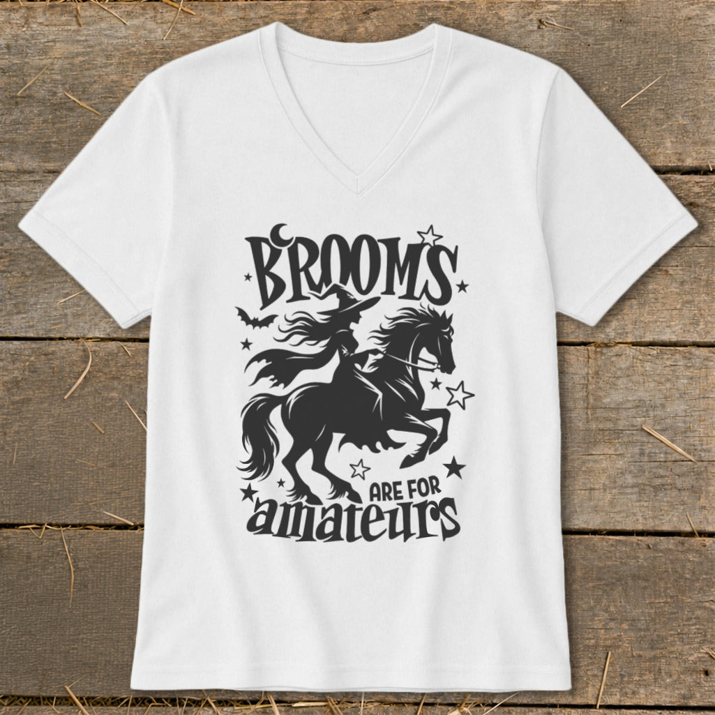 White v-neck shirt with black graphic: witch on horse, "Brooms are for amateurs" text.