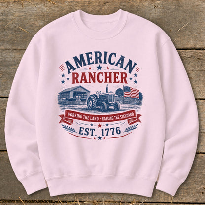 Pink sweatshirt with "American Rancher" graphic featuring tractor, barn, and American flag.