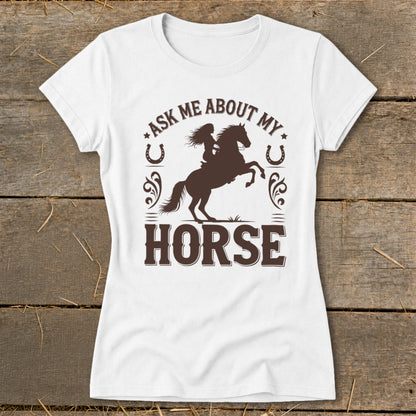 White t-shirt with brown graphic of a woman on a rearing horse and text "Ask Me About My Horse".
