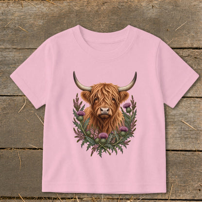 Pink t-shirt with Highland cow and thistles graphic design.