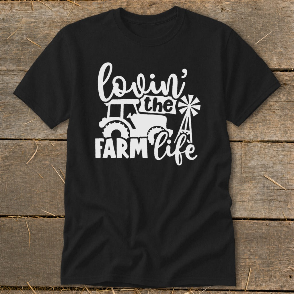 Black t-shirt with white text and graphic reading "lovin' the farm life" with tractor and windmill.
